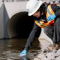 Pomerleau's Worker on a construction site in Vaudreuil, collecting water samples for environmental purposes