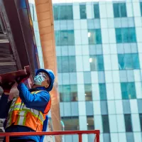 Construction worker with mask working on outside structure