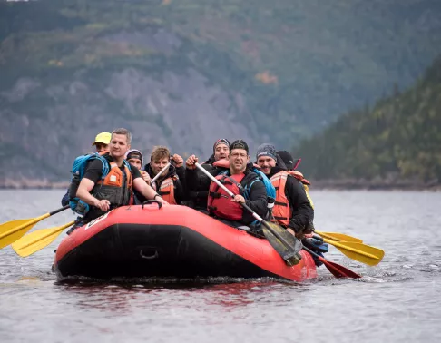 Group of people in a boat, paddling in a lake