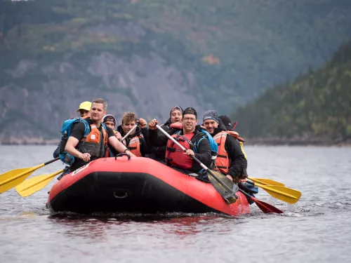 Group of people in a boat, paddling in a lake