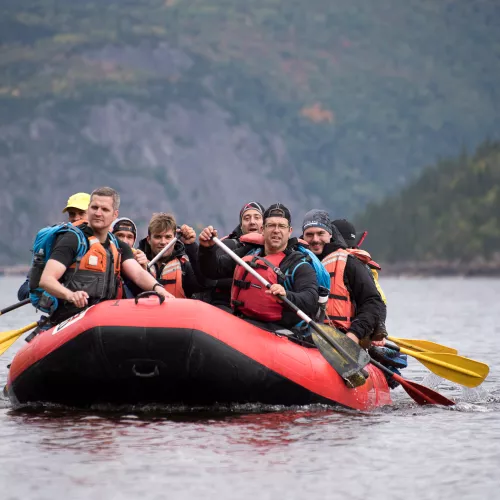 Group of people in a boat, paddling in a lake