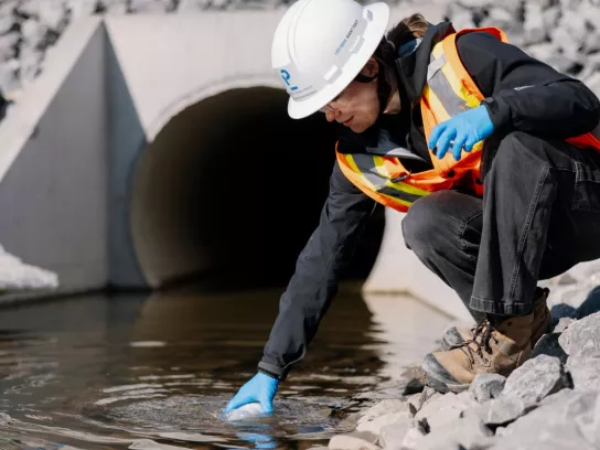 Pomerleau's Worker on a construction site in Vaudreuil, collecting water samples for environmental purposes