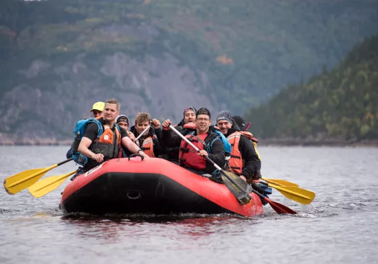 Group of people in a boat, paddling in a lake