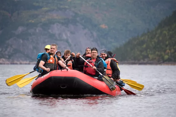 Group of people in a boat, paddling in a lake