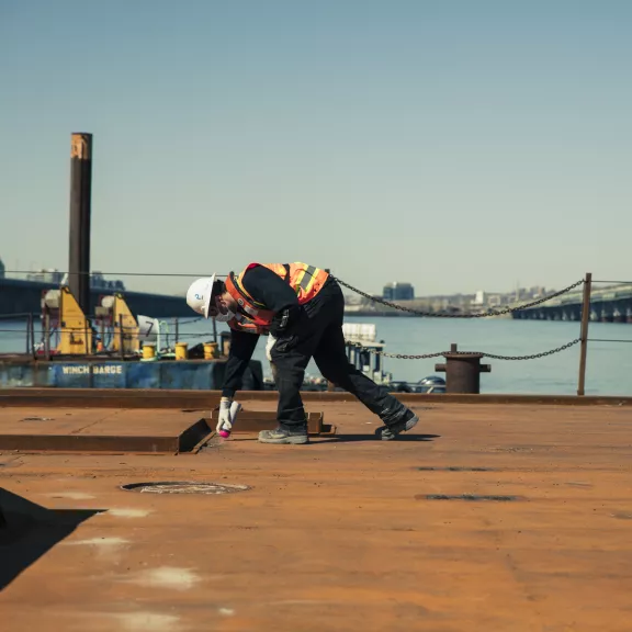 person applying paint to a bridge