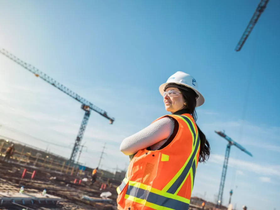Worker on a construction site with protective gear, an example of Pomerleau's commitment to safety in the Civil and Infrastructure Sector